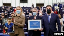 Leonid Volkov (desno) pozira sa kćerkom Alekseja Navaljnog Darijom (lijevo) i predsjednikom Evropskog parlamenta Davidom Sasolijem tokom ceremonije dodjele nagrade Saharov u Evropskom parlamentu u Strazburu, Francuska, 15. decembra 2021.