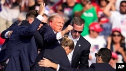 ABŞ-nyň ozalky prezidenti Donald Tramp mitingiň bolan ýerinden äkidilýär. 13-nji iýul