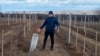 Heorhiy Molchanov stands by part of a bomb that juts from the earth at his Slivino Village winery near Mykolayiv, Ukraine. 