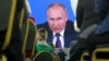 Президент РФ Владимир Путин (на экране) во время ежегодной большой пресс-конференции в Центральном выставочном зале «Манеж». Россия. Москва, 23 декабря 2021 года