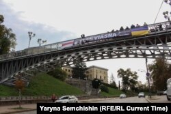 Банер з вимогою звільнити заарештованих співробітників правозахисного центру «Вясна» на мосту над алеєю Героїв Небесної сотні в Києві. Фото: Ярина Семчишин