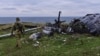 Український військовий на острові Зміїний у Чорному морі біля знищеного раніше російського гелікоптера, 18 грудня 2022 року, ілюстративне фото