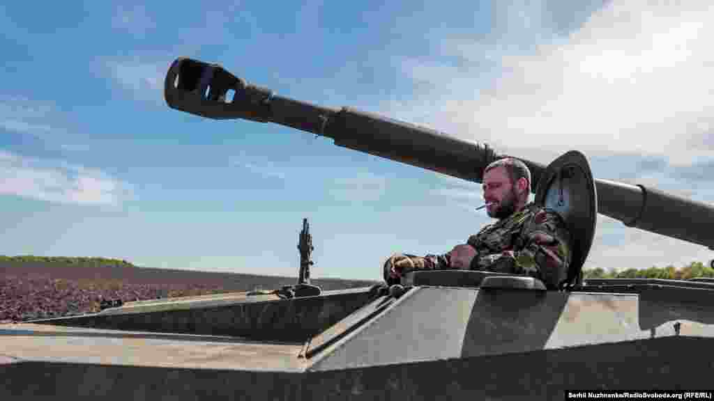 Украинский военный курит, сидя в 122-мм самоходной артиллерийской установке 2С1 «Гвоздика», Харьковщина, 7 мая 2022 года