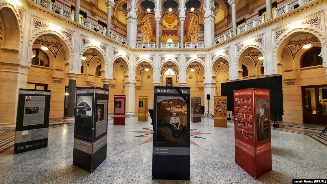 U Vijećnici u Sarajevu fotografije pričaju priče jedanaest žena koje su bile zatvorene u logorima, u njihovom sadašnjem okruženju - bašti, biblioteci crkvi, učionici.