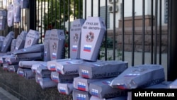 Десятки картонных гробов возле здания посольства России в Киеве. Гробы украшены российскими флагами и надписью «Груз 200.ЧВК Вагнера».