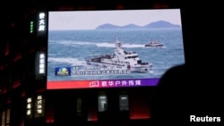 A China Coast Guard vessel is seen on a giant screen showing news footage about the coast guard's patrols in waters around Taiwan on April 1. 