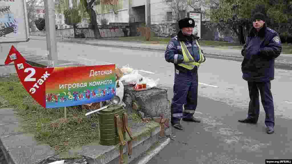Добросердечные старушки пытаются угостить милиционеров, дежурящих в оцеплении. Те категорически отказываются и перекусывают развозимым интендантскими службами пайком и супом из армейских ранцевых термосов.