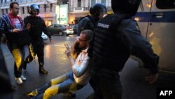 Полицейские задерживают сторонника оппозиции во время акции протеста в Москве. Согласно докладу Freedom House, Россия показала «драматический спад» по демократическим показателям.
