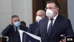 Главният държавен здравен инспектор Ангел Кунчев (вляво), председателят на Националния оперативен щаб Венцислав Мутафчийски и здравният министър Костадин Ангелов по време на брифинга на 31 декември 2020.