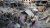 Palestinezë duke inspektuar vendin e një sulmi izraelit mbi një shtëpi, në Jabalia, në veri të Rripit të Gazës, më 18 maj 2025.