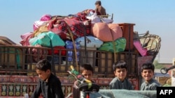 Afghan refugee children board trucks loaded with their belongings as they wait to depart for Afghanistan at a holding centre near the Pakistan-Afghanistan border in Chaman on April 27, 2025.