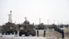 FILE: NATO soldiers keep watch near the wreckage of their vehicle at the site of a Taliban suicide attack in Kandahar on September 15.