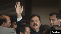 Pakistanyň premýer-ministri Ýusuf Reza Gilani suduň zalyndan ýylgyryp we tarapdarlaryna elini salgap çykdy. Yslamabat, 26-njy aprel, 2012.