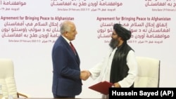 (ښی) قطر کې د طالبانو د سیاسي دفتر مشر ملا برادر (کین) د افغان سولې لپاره د امریکا ځانګړی استازی زلمی خلیلزاد.