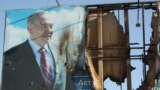 Поврежденный баннер с изображением президента Нурсултана Назарбаева в городе Жанаозен Мангистауской области, 19 декабря 2011 года. 