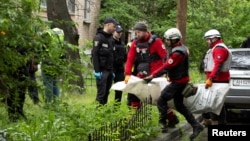 Рятувальники несуть тіло загиблого внаслідок удару російської атаки на Київ, 7 травня 2025 року