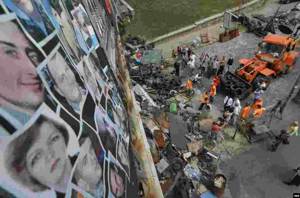 Slike onih koji su izgubili živote su prikačene na most, a komunalni radnici uklanjaju barikade i čiste Trg nezavisnosti. Centar Kijeva ponovo je otvoren za saobraćaj, 11. avgust 2014.