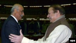 د پاکستان وزیر اعظم نواز شریف د پیپلز ګوند پارلماني مشر خورشید شاه سره روغبړ کوي