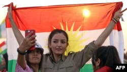 A woman holds a flag during a gathering to support the Kurdistan independence referendum on September 21. 