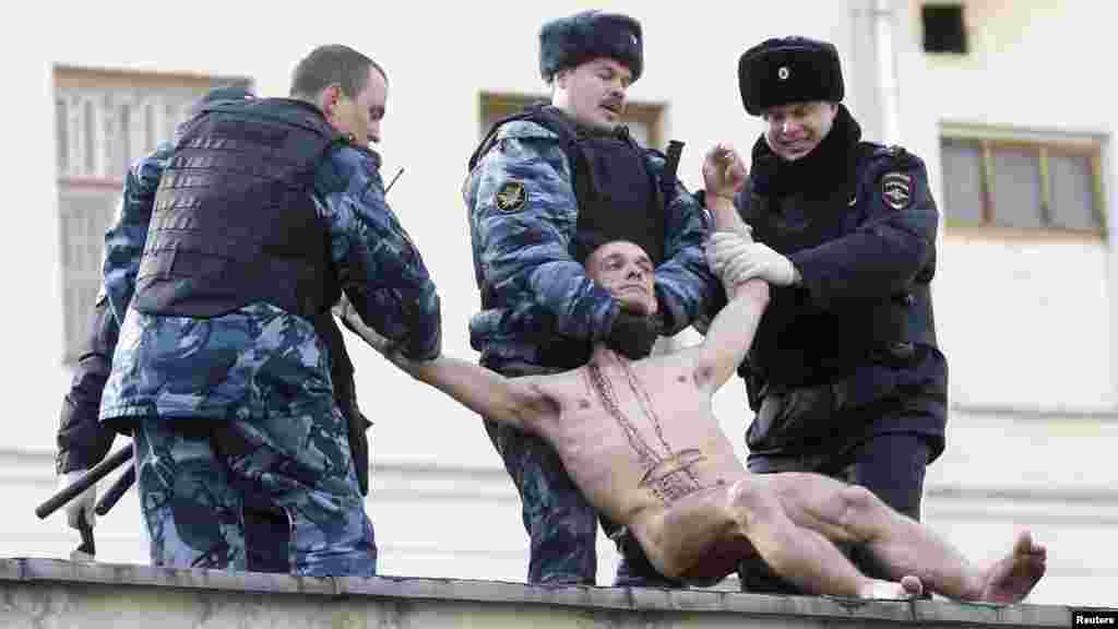 Полиция Павленскийны дивардан сүрәп төшерә