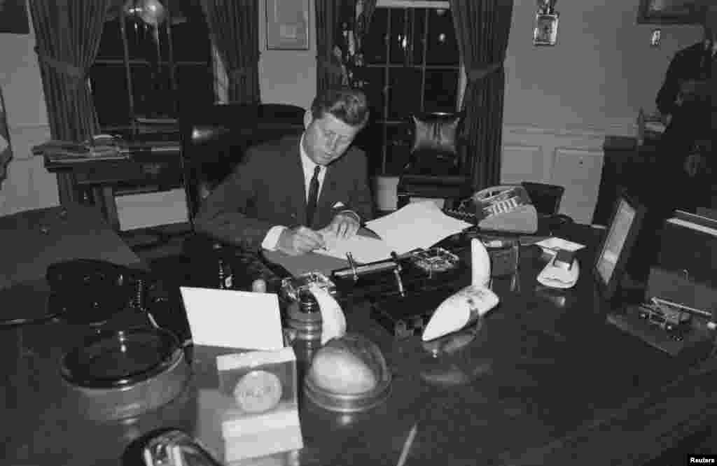 جمهور رییس جان اف. کنېډي په کیوباکې د راکټي بحران پر مهال، کیوبا ته د وسلو د لېږل د درولو اعلامیه لاسلیک کوي. ۲۳ اکتوبر ۱۹۶۲.
