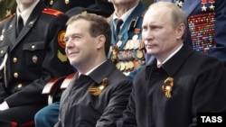 Orsýetiň prezidenti Dmitriý Medwedew (çepde) we premýer-ministr Wladimir Putin Moskwanyň Gyzyl meýdançasynda harby parada tomaşa edýär, 2011-nji ýylyň 9-njy maýy.