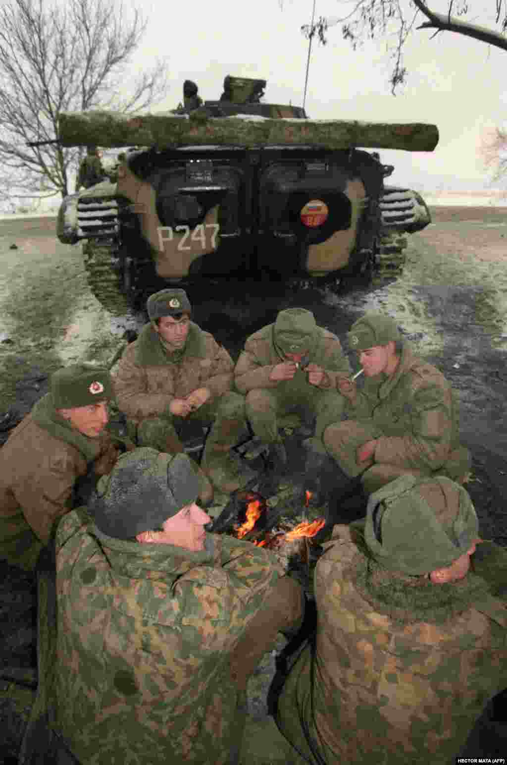 Российские военнослужащие греются у костра в дагестанском Хасав-юрте на границе с Чеченской республикой, ожидая приказа двинуться на Грозный. 22 декабря 1994 года.