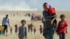 Iraq -- Displaced people from the Yezidi community, fleeing violence from forces loyal to the Islamic State in Sinjar town, walk towards the Syrian border, on the outskirts of Sinjar mountain, near the Syrian border town of Elierbeh of Al-Hasakah Gove