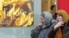 Две пожилые женщины идут мимо рекламы парфюма. Москва, 30 декабря 2004 года.