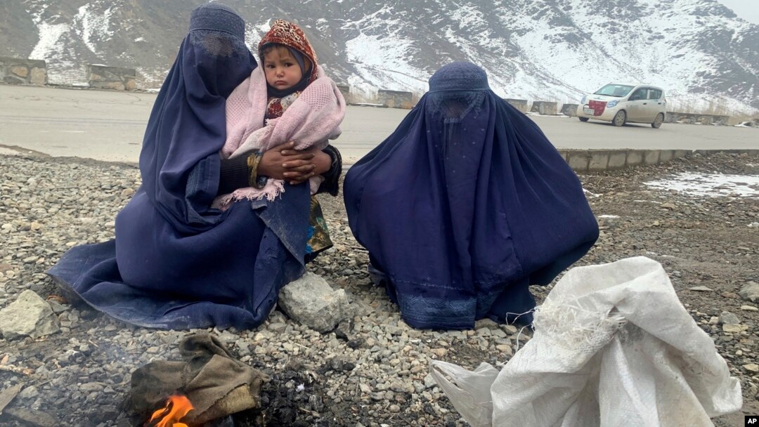 په کابل کې دوو ښځو د سړک پر غاړه له يو ماشوم سره د ځان تودولو لپاره اور بل کړی دی ـ انځور له ارشيفه