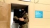 RUSSIA -- A masked law enforcement officer addresses journalists during a raid in a local office of Kremlin critic Aleksei Navalny in Perm, September 12, 2019