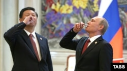 Hytaýyň prezidenti Si Jinping (Ç) rus kärdeşi Wladimir Putin bilen tebigy gaz şertnamasyna gol çekilmeginiň şanyna bada göterýär. Şanhaý, 21-nji maý, 2014.