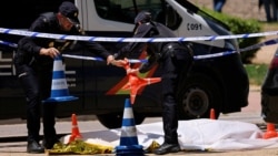 Spanish police officers work near the body of Andriy Portnov, a Ukrainian lawyer who was shot and killed by unidentified gunmen outside a school in Madrid on May 21.