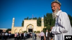 Марде дар роҳ ба намози Иди Фитр дар шаҳри Қошғар, Шинҷон. Соли 2017