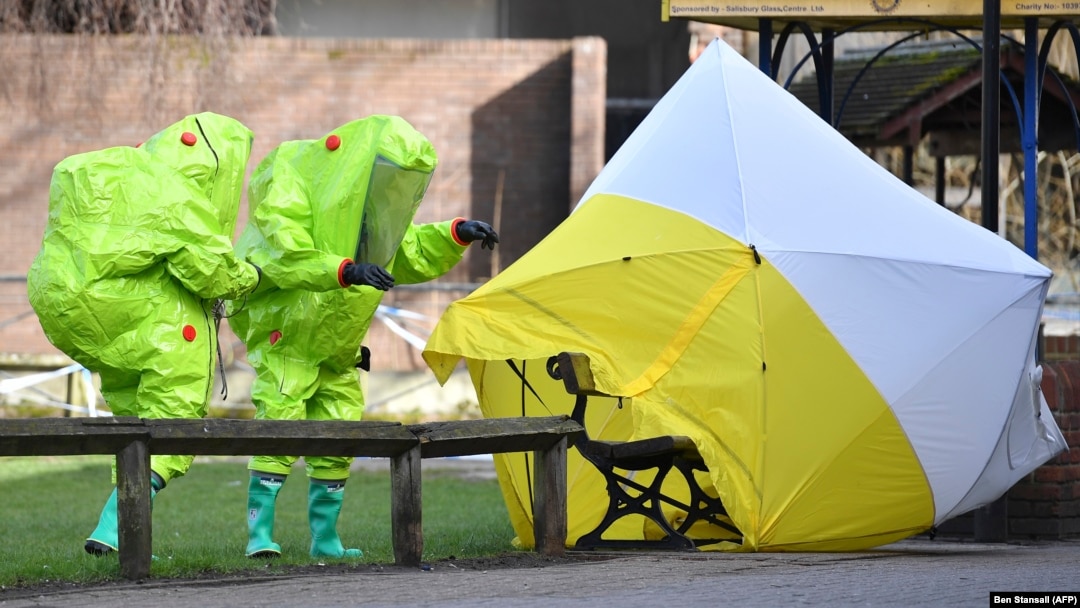 British emergency service workers in green biohazard suits place a the tent over the bench where Sergei Skripal and his daughter, Yulia, were found in critical condition on March 4.