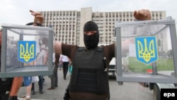 Orsýete tarapdar separatist saýlaw nokadyndan alnan gapyrjaklary tutup dur, Donetsk, 23-nji maý, 2014. 
