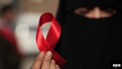 د ډېسېمبر پر لومړۍ د اېډز د نړېوالې ورځې په مناسبت یوې مېرمنې سره فیته نیولې ده. 