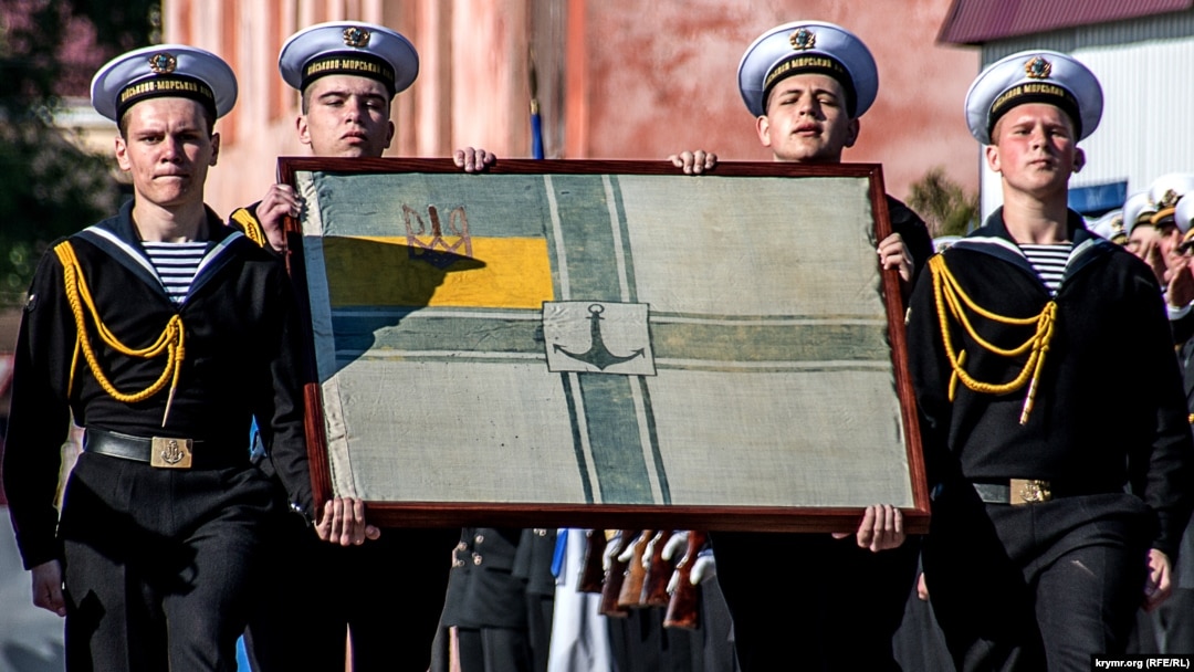 Цей військово-морський прапор виготовив у 1918 році старший лейтенант Військово-морського флоту УНР Святослав Шрамченко. Згодом передав його до Українського національного музею в Чикаго. До Одеси на урочистості до 100-ліття ВМС України прапор привезла куратор музею Марія Климчак. Вона пообіцяла назавжди передати його Україні після того, як Крим буде звільнено з під окупації Росією. Одеса, 29 квітня 2018 року